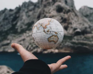 a globe floating above a person's outstretched palm